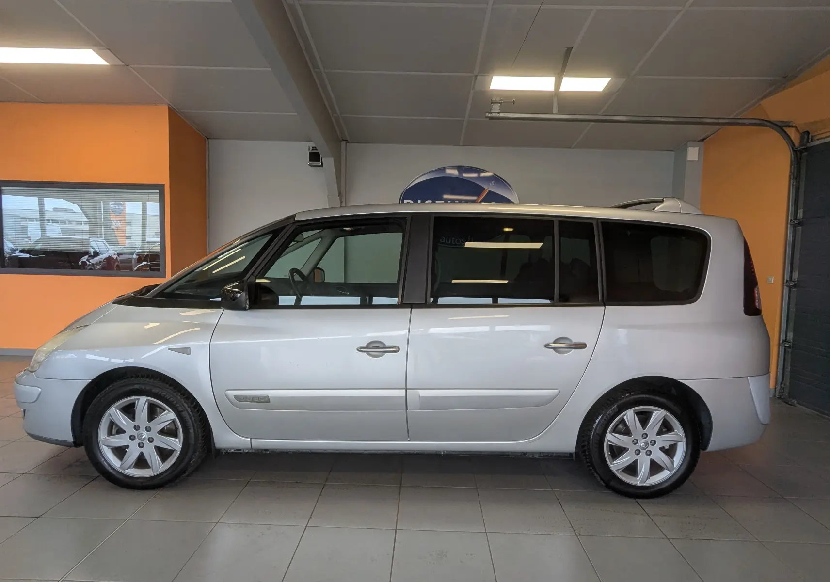 Profil côté gauche d'un Renault Grand Espace IV gris clair de 2012, monospace 7 places avec jantes alliage.