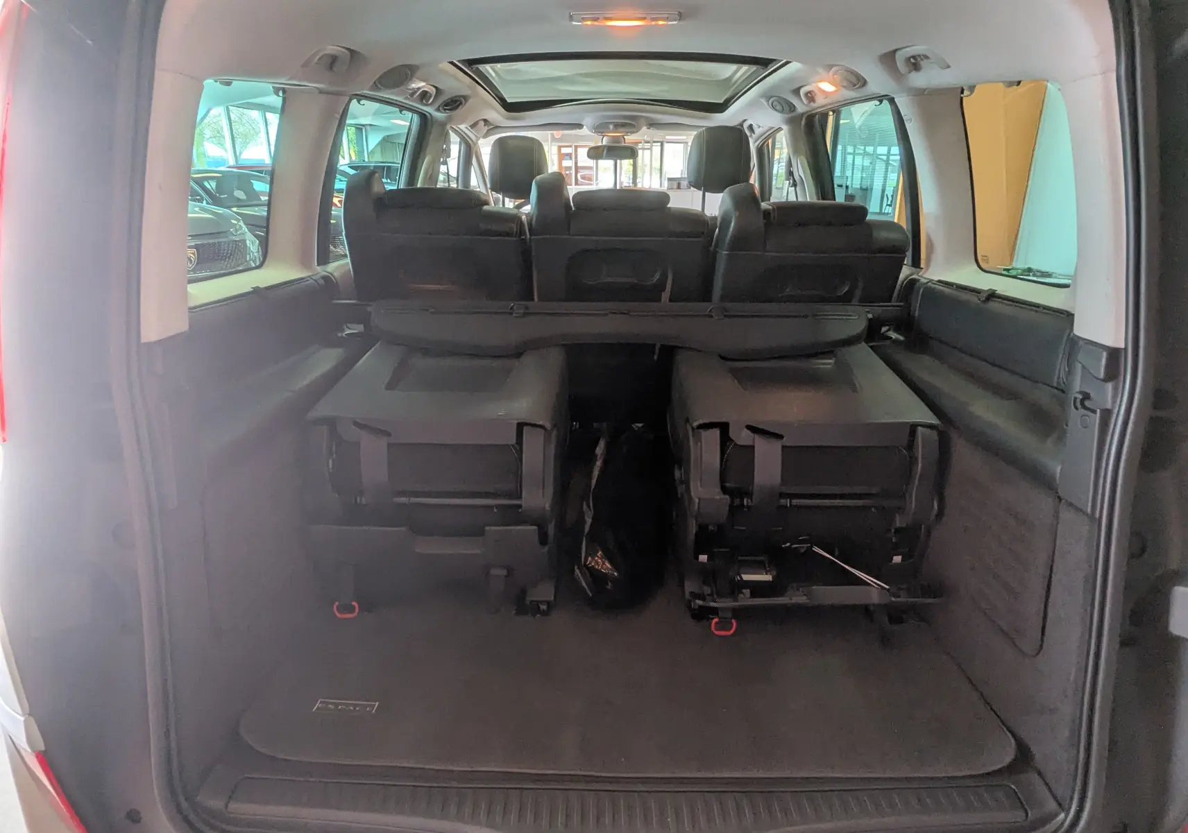 Vue arrière ouverte du coffre du Renault Grand Espace IV gris clair, montrant les sièges arrière rabattus et l'intérieur spacieux.