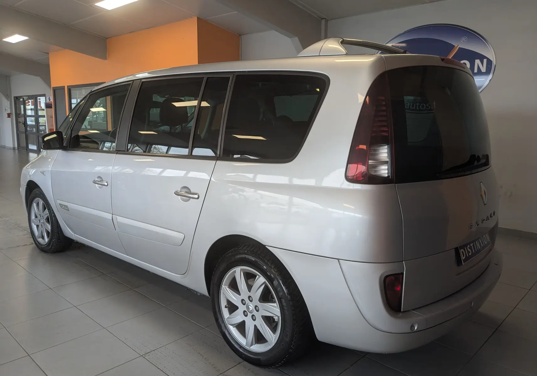 Vue 3/4 arrière droit d’un Renault Grand Espace IV gris clair, avec vitres teintées et jantes alliage 17 pouces.