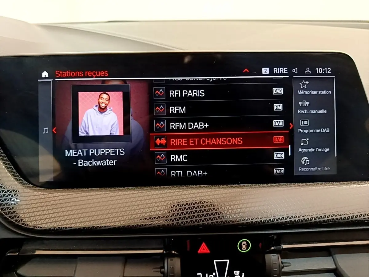 Écran tactile central de 10,25 pouces affichant les stations radio dans une BMW Série 1 118i Edition Sport 2023.