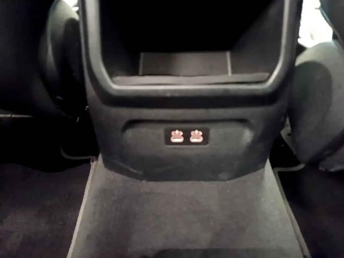 Vue rapprochée de la console centrale arrière noire avec prises USB dans une BMW Série 1 bleu Edition Sport 2023.