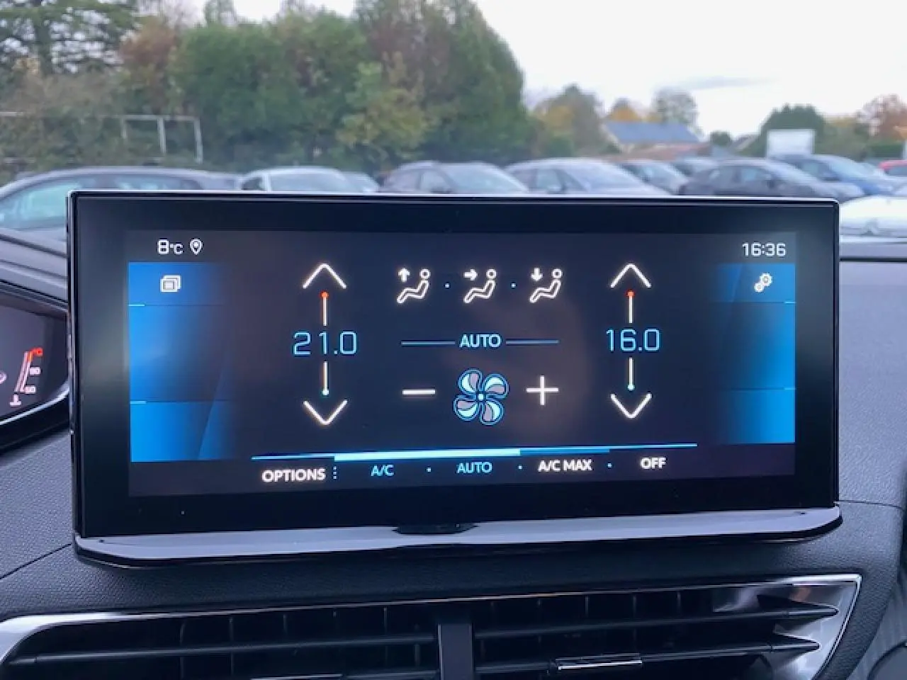 Écran tactile du tableau de bord d’un Peugeot 5008 noir, affichant la climatisation bi-zone en mode automatique.