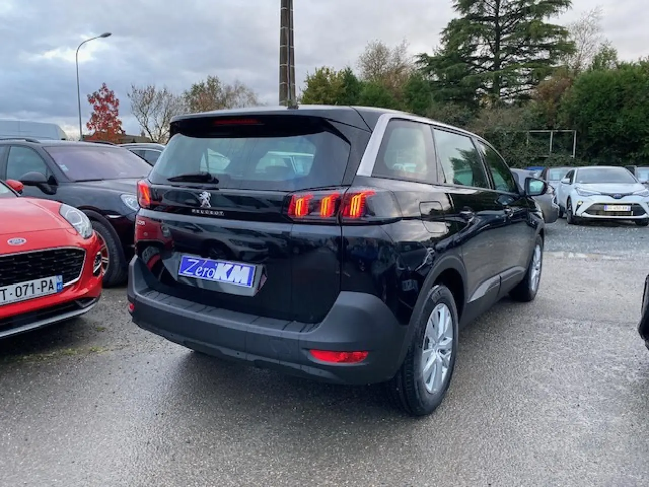 Peugeot 5008 noir vue 3/4 arrière droit avec feux arrière LED et jantes alliage 16 pouces.