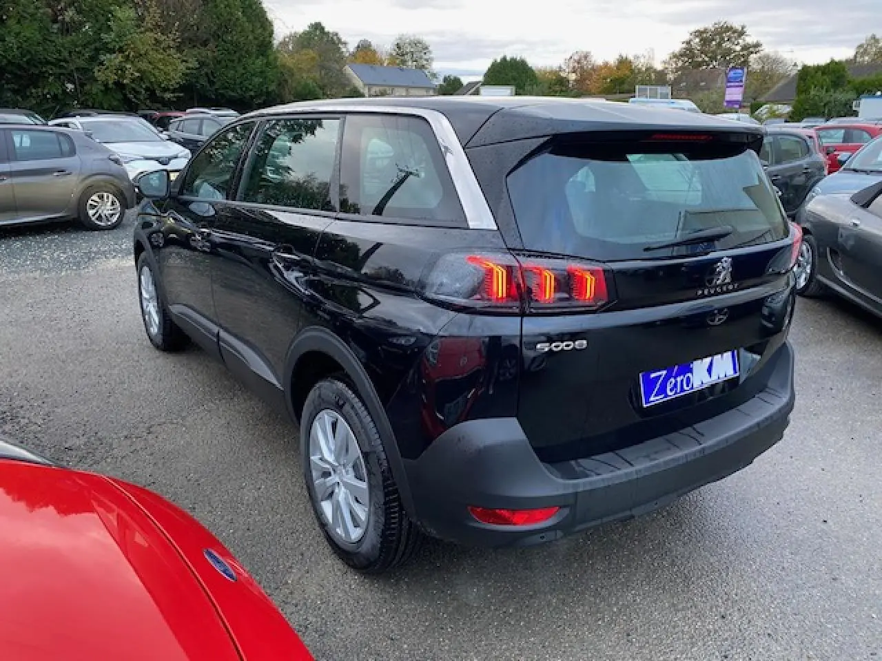 Vue 3/4 arrière droite d’un Peugeot 5008 noir 2023 avec feux arrière LED et jantes alliage 16 pouces.