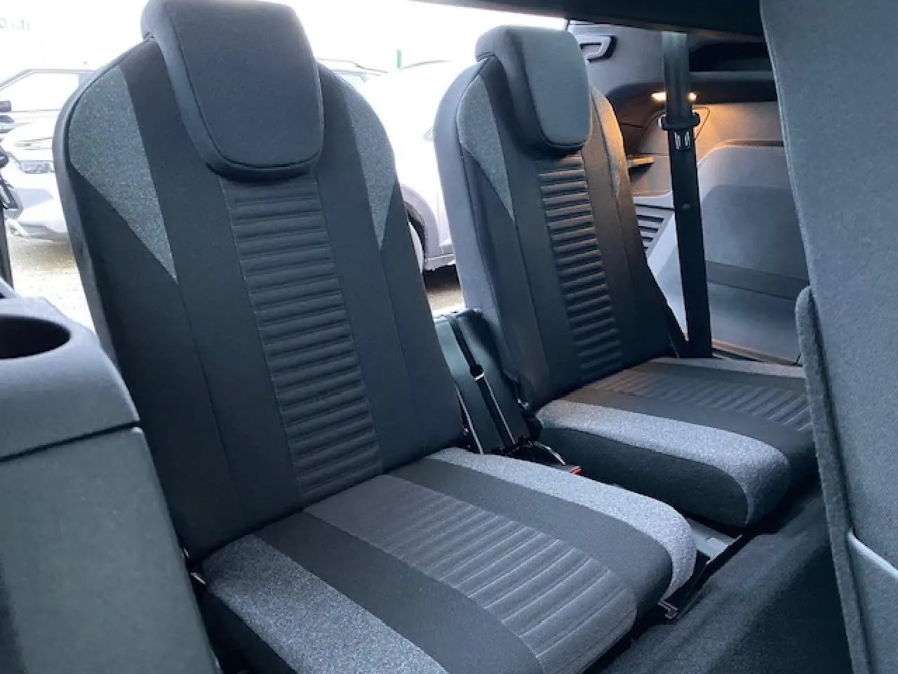 Vue intérieure sur les sièges arrière du Peugeot 5008 2023, tissu noir et gris, avec ceinture de sécurité visible.