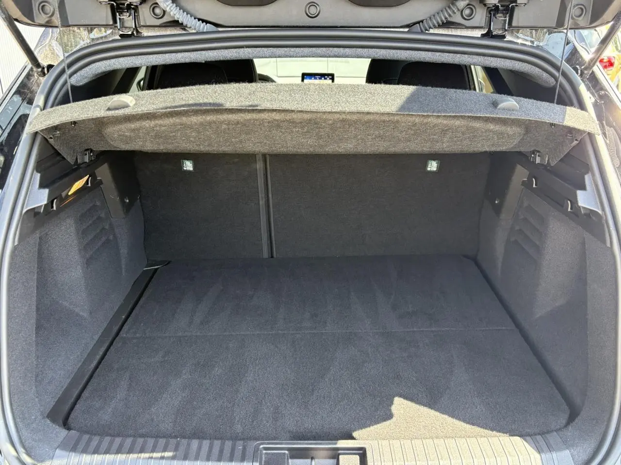 Coffre ouvert vu de l’arrière du Renault SYMBIOZ noir étoilé, montrant un espace de chargement propre et spacieux.