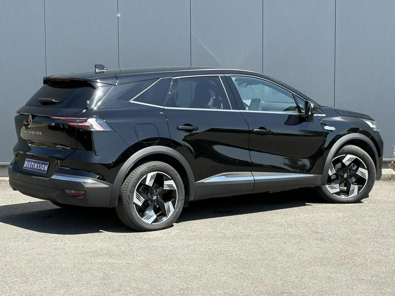Vue 3/4 arrière droite d’un Renault SYMBIOZ noir étoile avec jantes 18 pouces et feux arrière LED distinctifs.