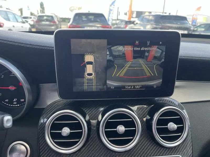 Vue intérieure du tableau de bord d’un Mercedes GLC Coupé blanc, écran affichant la caméra 360° en marche.