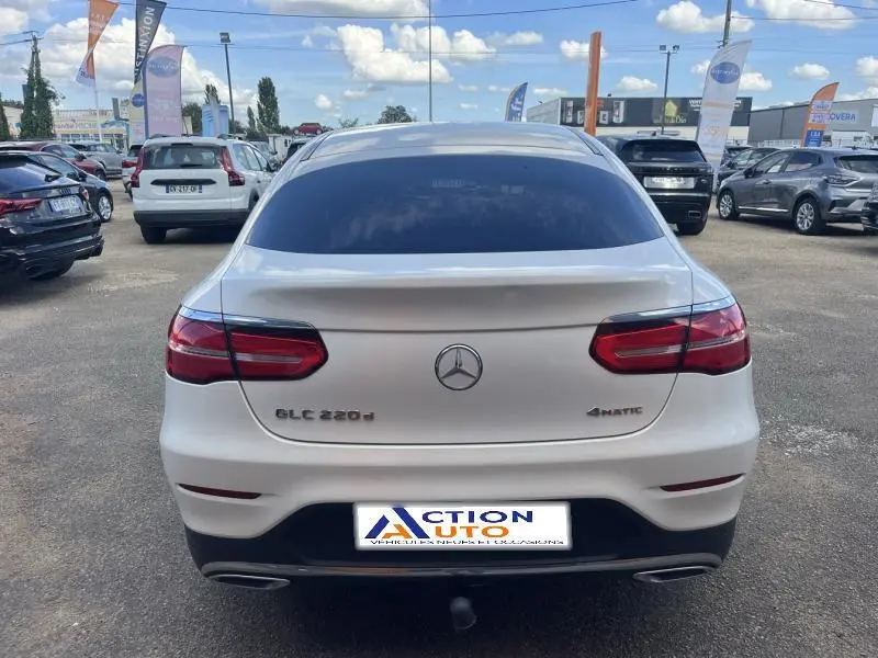Vue arrière d’un Mercedes GLC Coupé 220 d blanc diamant brillant avec feux arrière LED et vitres surteintées.