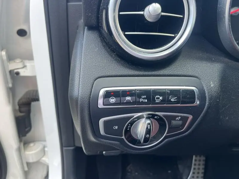 Détail du tableau de bord côté gauche avec commandes d’éclairage et caméra 360° sur Mercedes GLC Coupé blanc diamant.