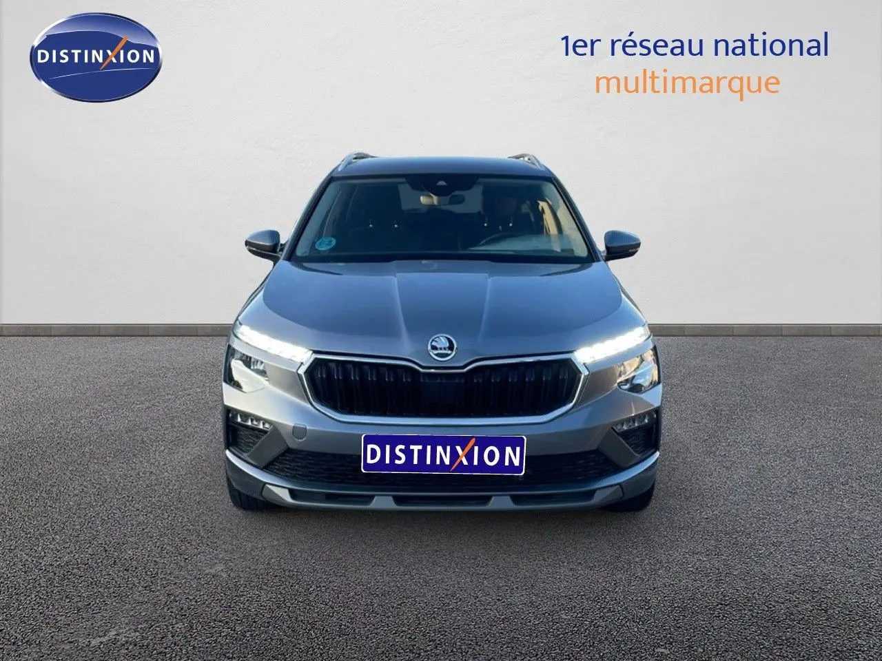 Vue frontale d'un Skoda Kamiq gris graphite métal 2024 avec feux LED allumés sur fond neutre.