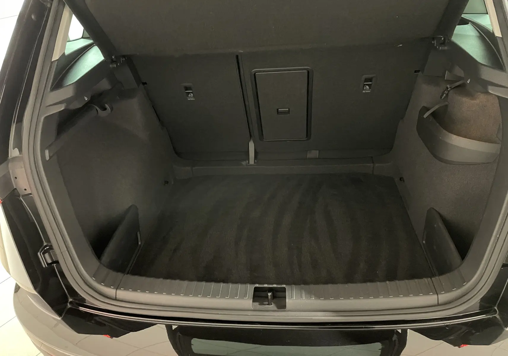 Coffre ouvert du Skoda Karoq noir Magic nacré, vue arrière montrant l'espace de chargement vide et les finitions intérieures.