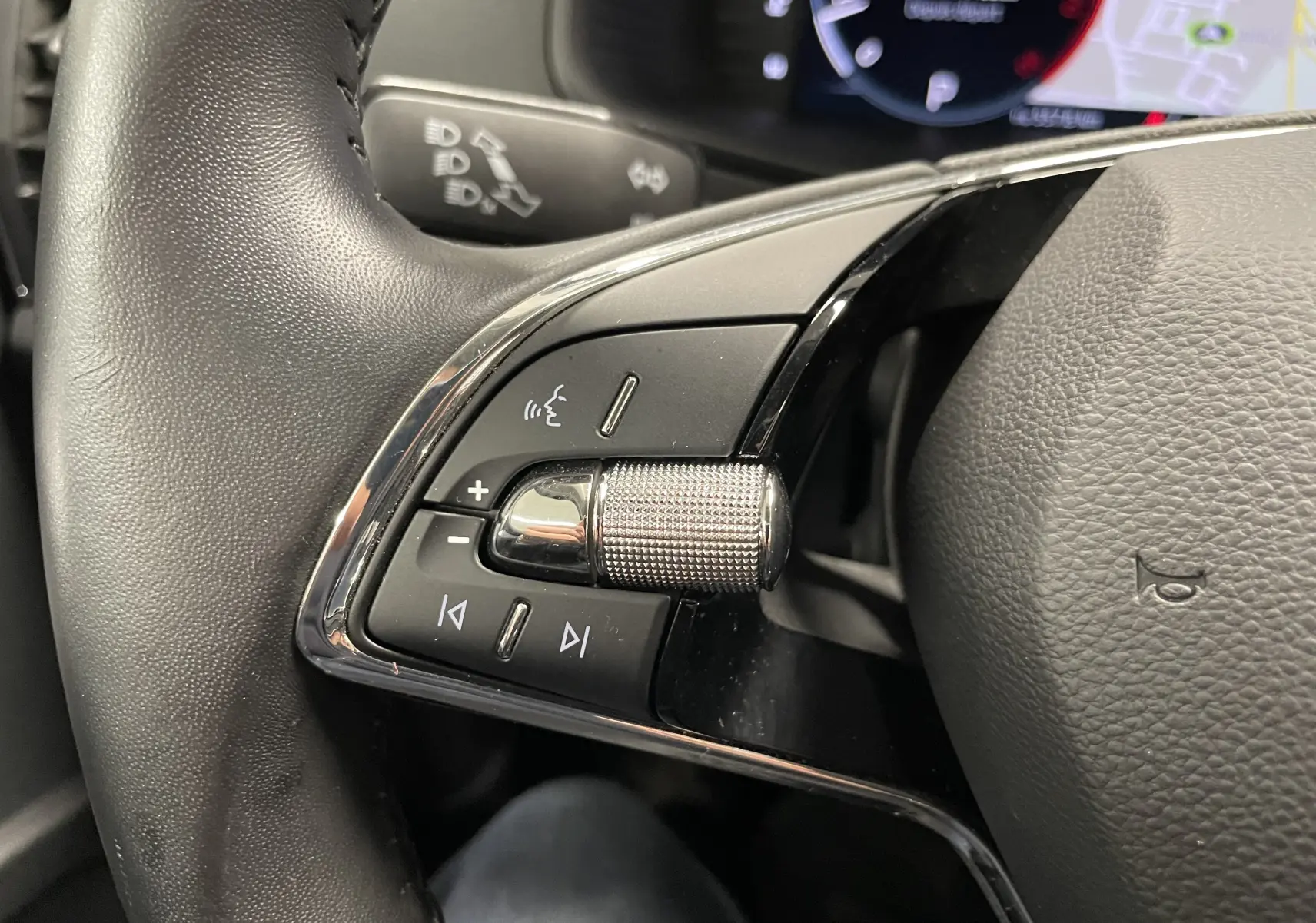 Gros plan sur les commandes gauche du volant cuir noir du Skoda Karoq 1.5 TSI 150 DSG7 Business 2023.