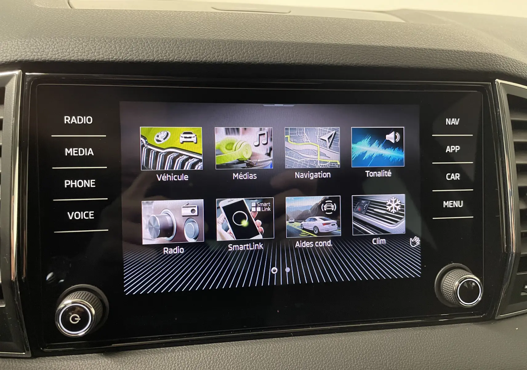 Écran tactile central du Skoda Karoq 2023 affichant les menus multimédias et aides à la conduite.