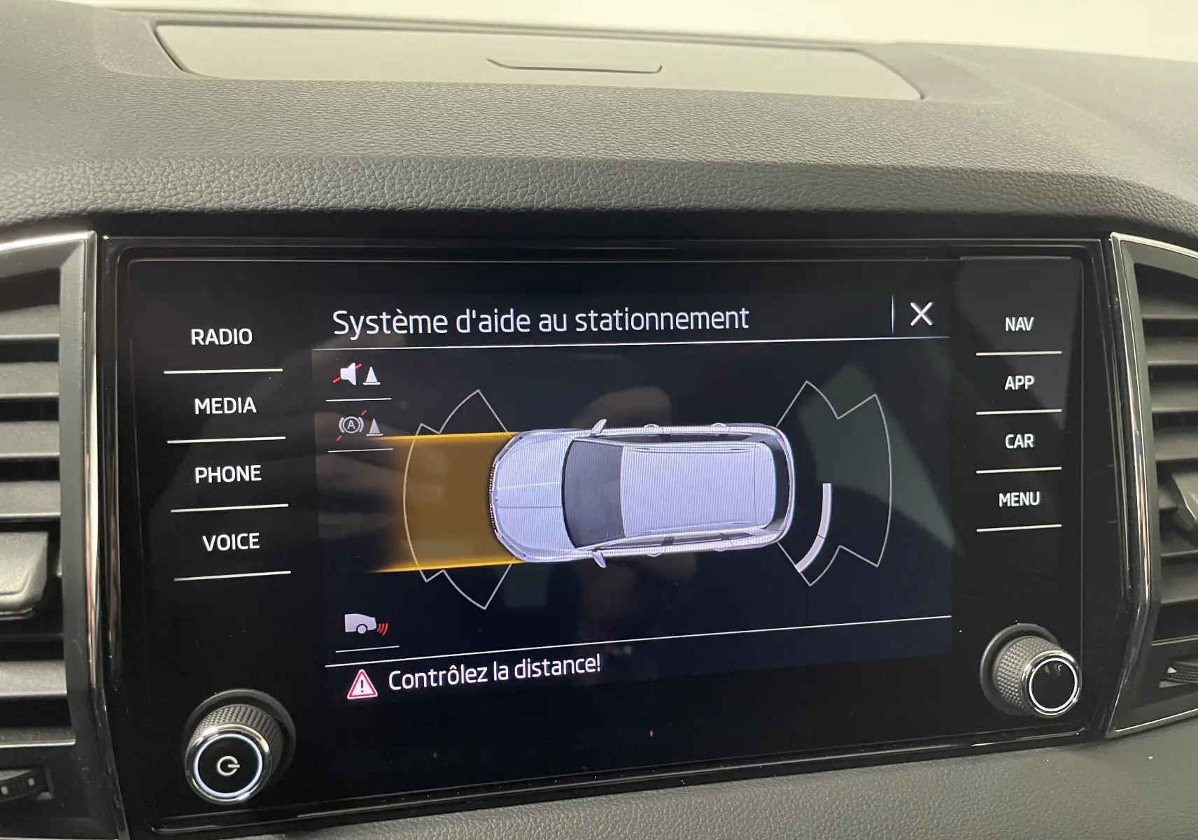 Écran tactile du système d'aide au stationnement dans un Skoda Karoq 2023, affichant les capteurs avant et arrière.