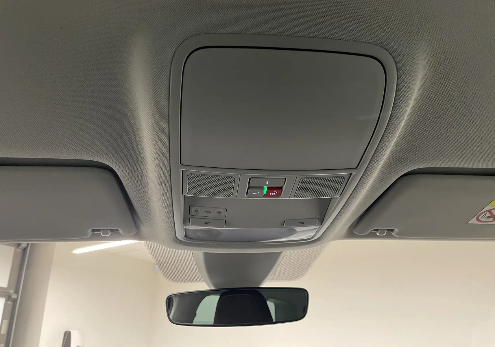 Plafonnier intérieur avec commandes d'éclairage et bouton SOS du Skoda Karoq 2023 vue depuis l'habitacle avant.