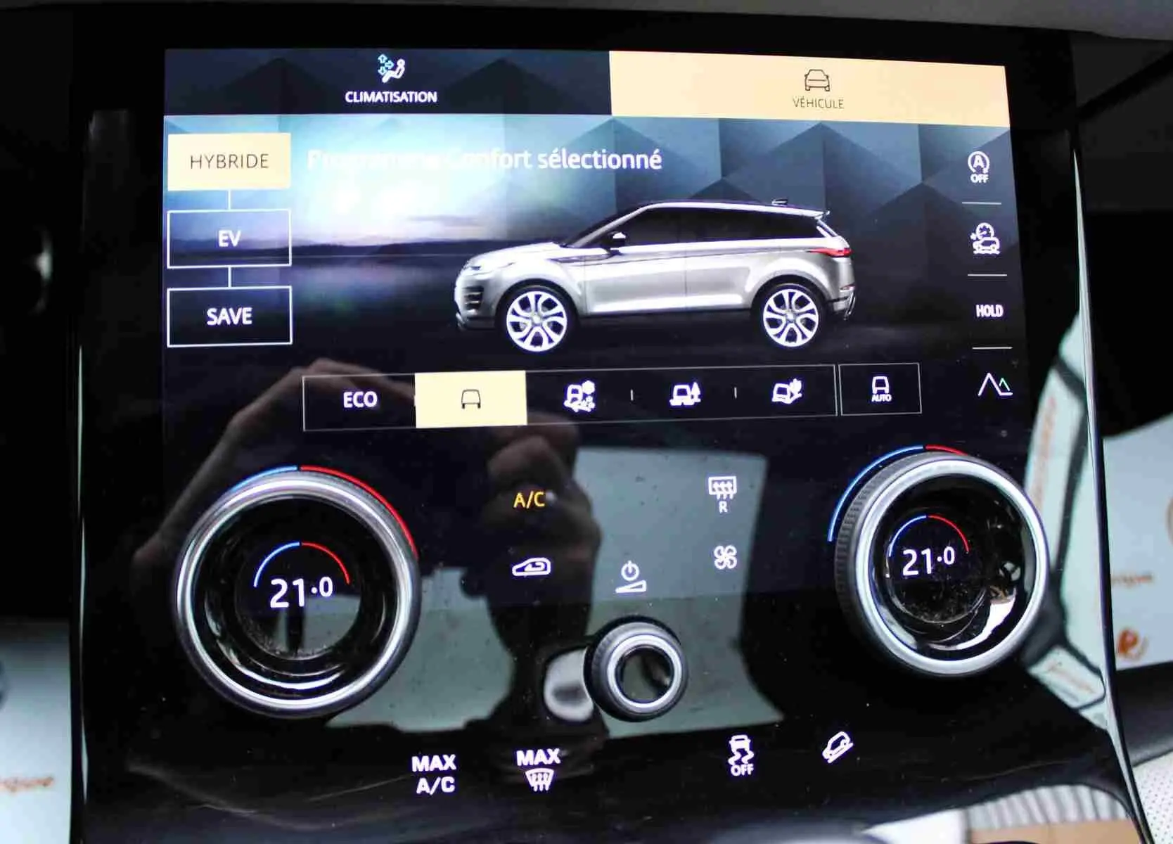 Écran tactile intérieur montrant le profil gris métal du Range Rover Evoque hybride rechargeable en vue latérale droite.