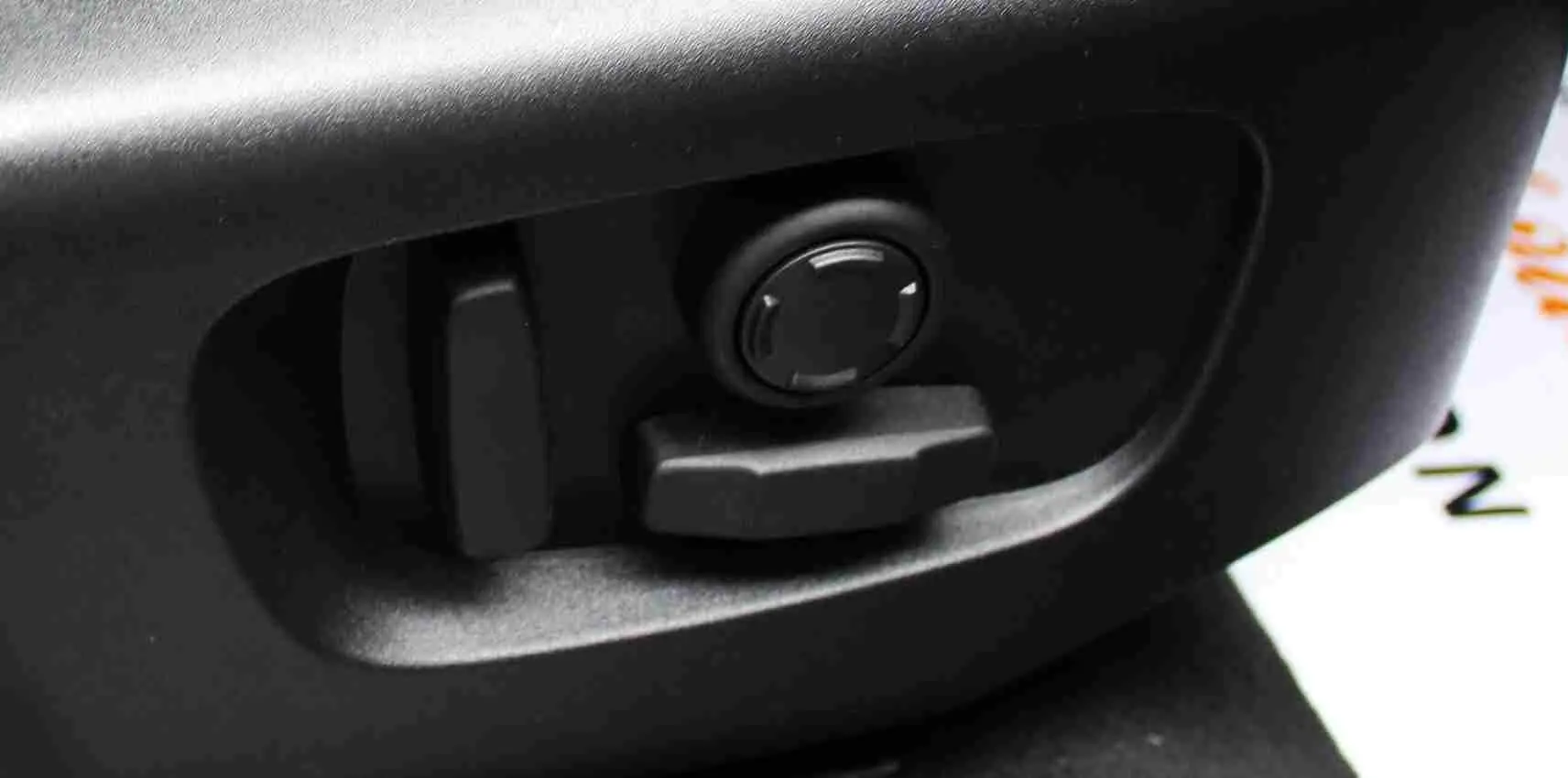 Réglage électrique des sièges en gros plan dans l'habitacle du Range Rover Evoque gris métal 2023.