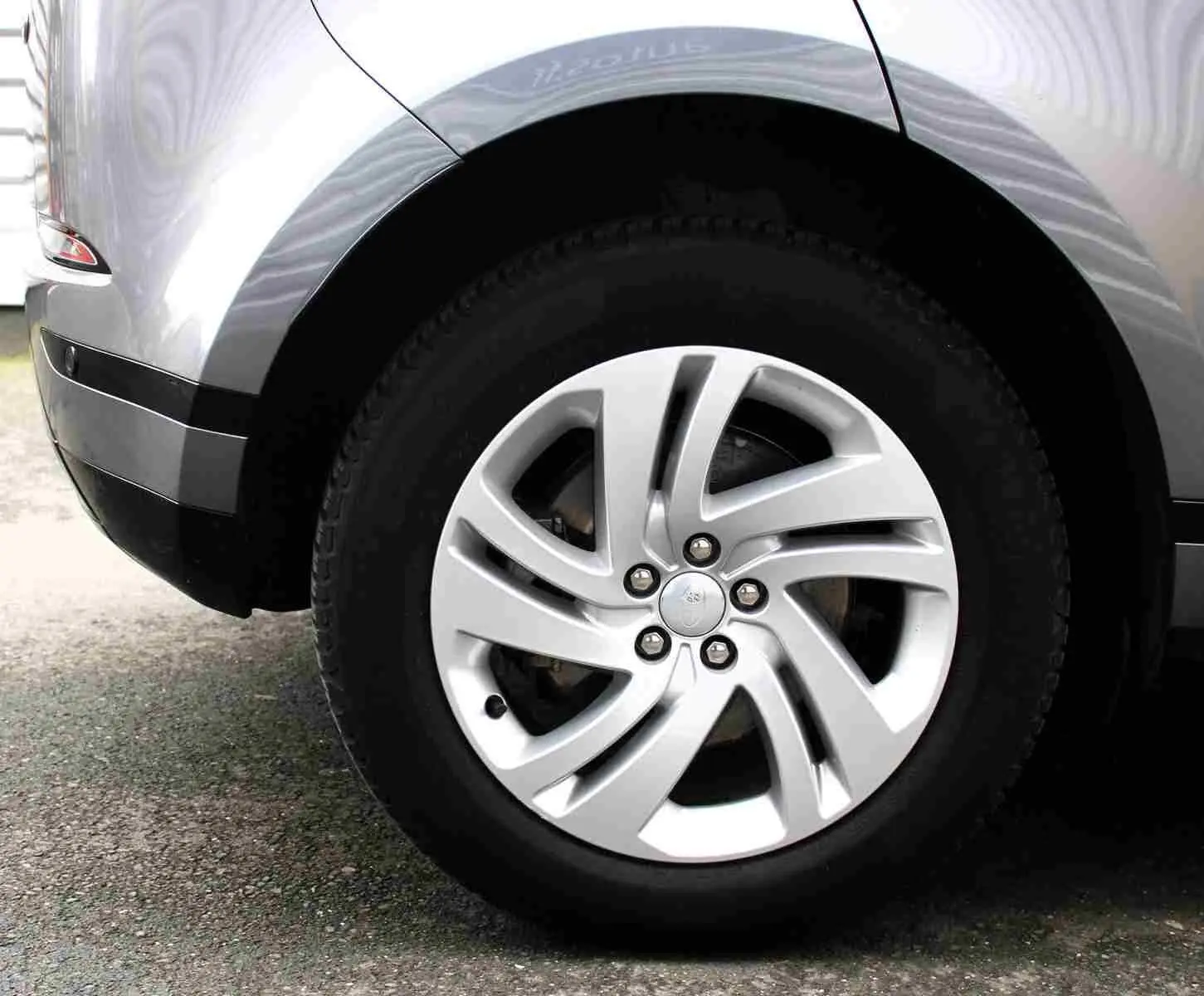 Gros plan sur la roue arrière droite du Range Rover Evoque gris métal 2023, mettant en valeur la jante alliage design.