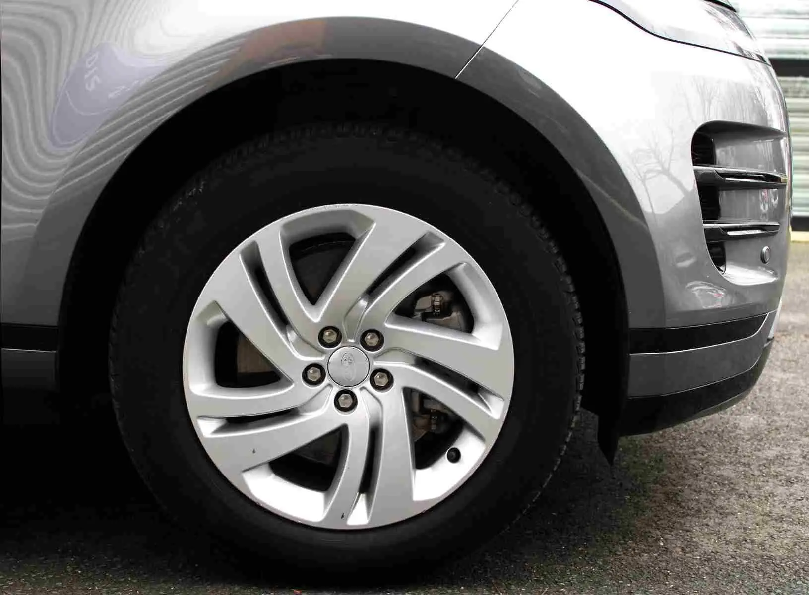 Gros plan sur la roue avant droite gris métal du Range Rover Evoque 2023 avec jante alliage à cinq branches torsadées.
