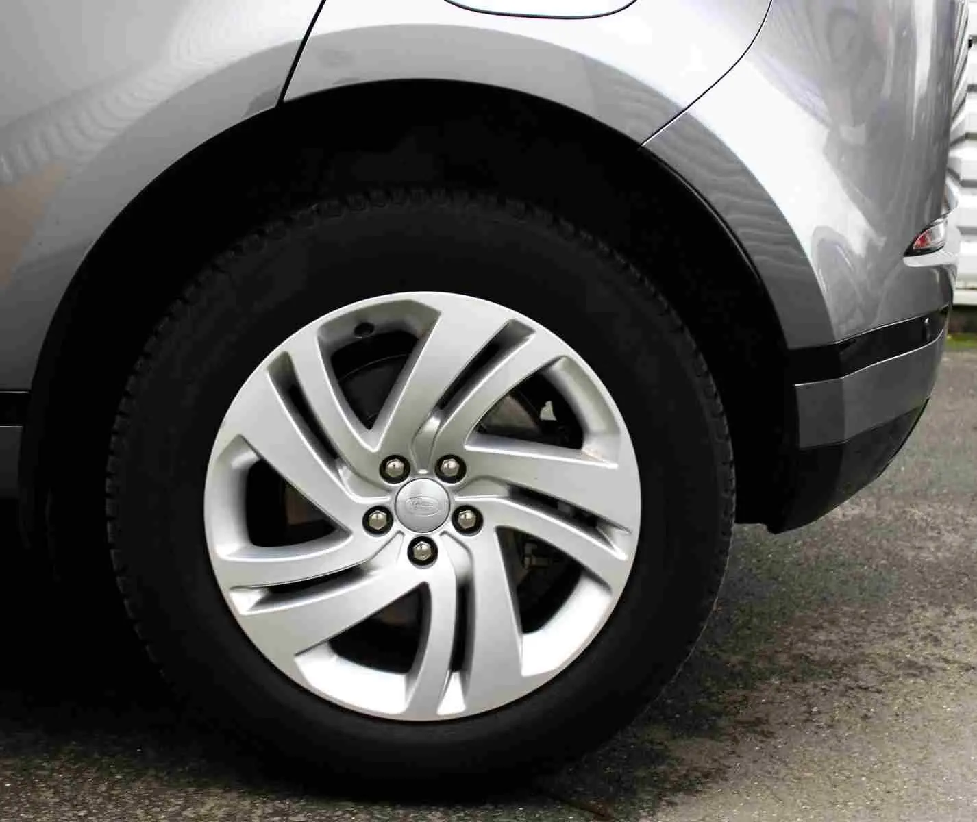 Gros plan sur la roue arrière droite du Range Rover Evoque gris métal 2023, mettant en valeur la jante alliage distinctive.