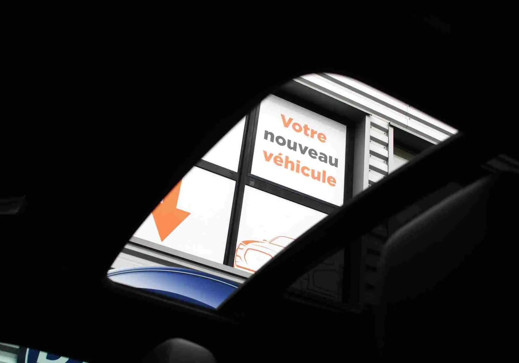 Vue partielle depuis l'intérieur montrant le toit ouvrant d'un Range Rover Evoque gris métal 2023.