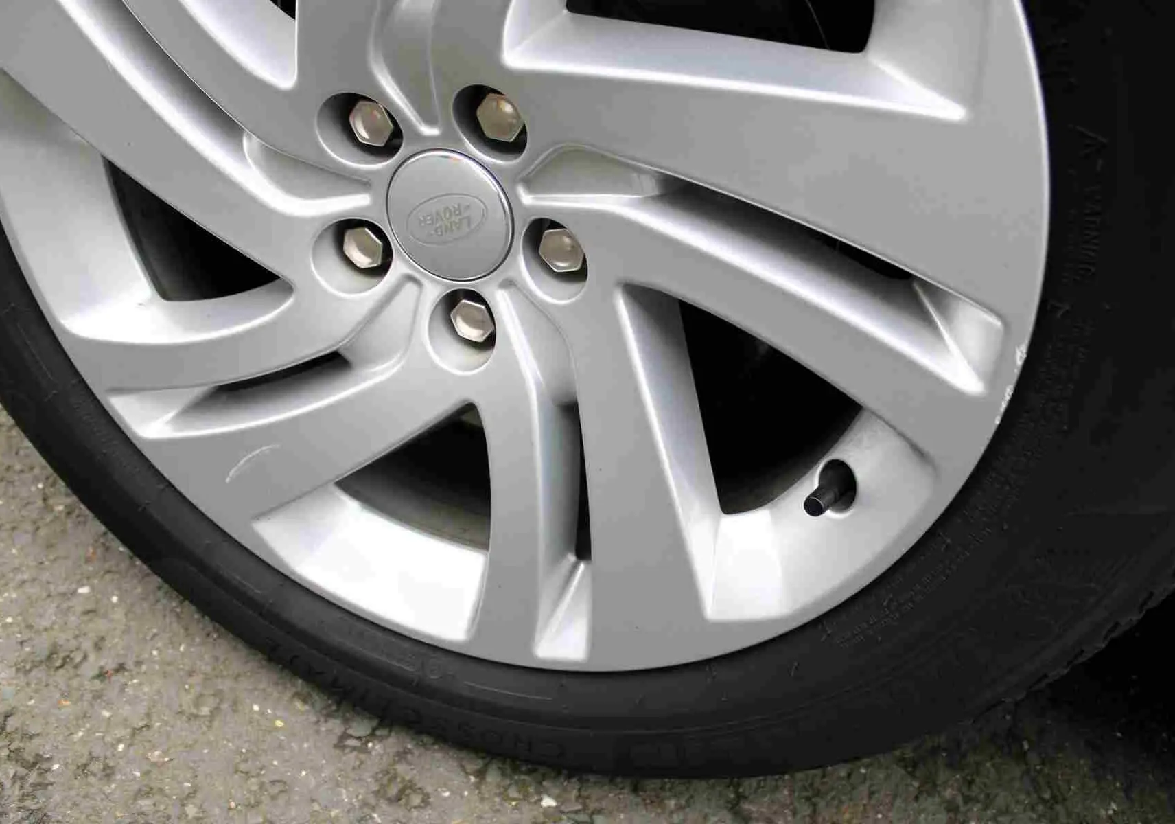 Gros plan sur la jante argentée du Range Rover Evoque 2023, mettant en valeur le logo Land Rover au centre.