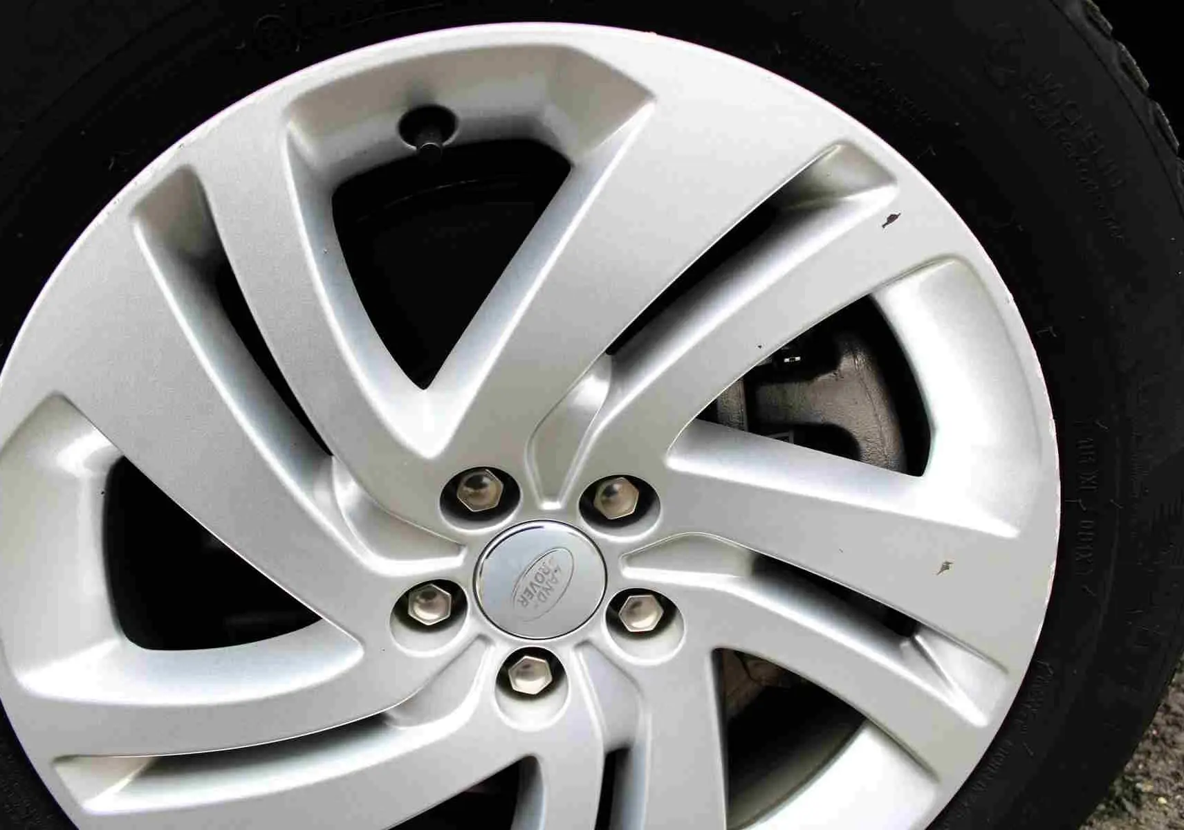 Gros plan sur la jante argentée du Range Rover Evoque 2023, mettant en valeur le logo Land Rover au centre.