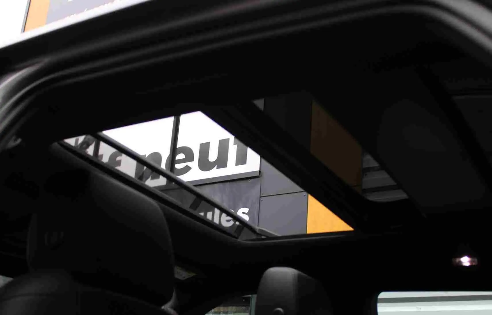 Vue intérieure du toit ouvrant panoramique du Range Rover Evoque gris métal 2023, version hybride rechargeable.