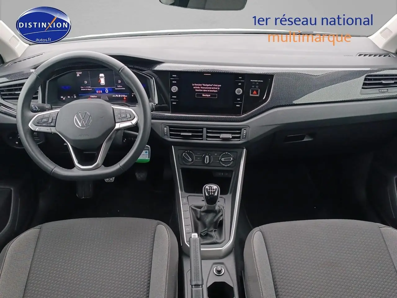 Intérieur avant de la Volkswagen Polo blanche 2025, vue centrée sur le tableau de bord et la boîte manuelle.