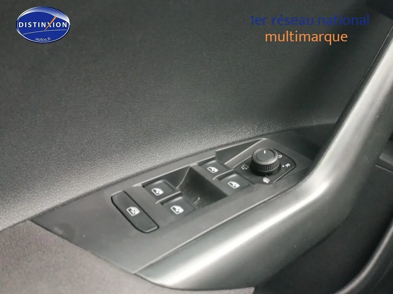 Vue rapprochée du panneau de commandes des vitres et rétroviseurs côté conducteur d'une Volkswagen Polo blanche.