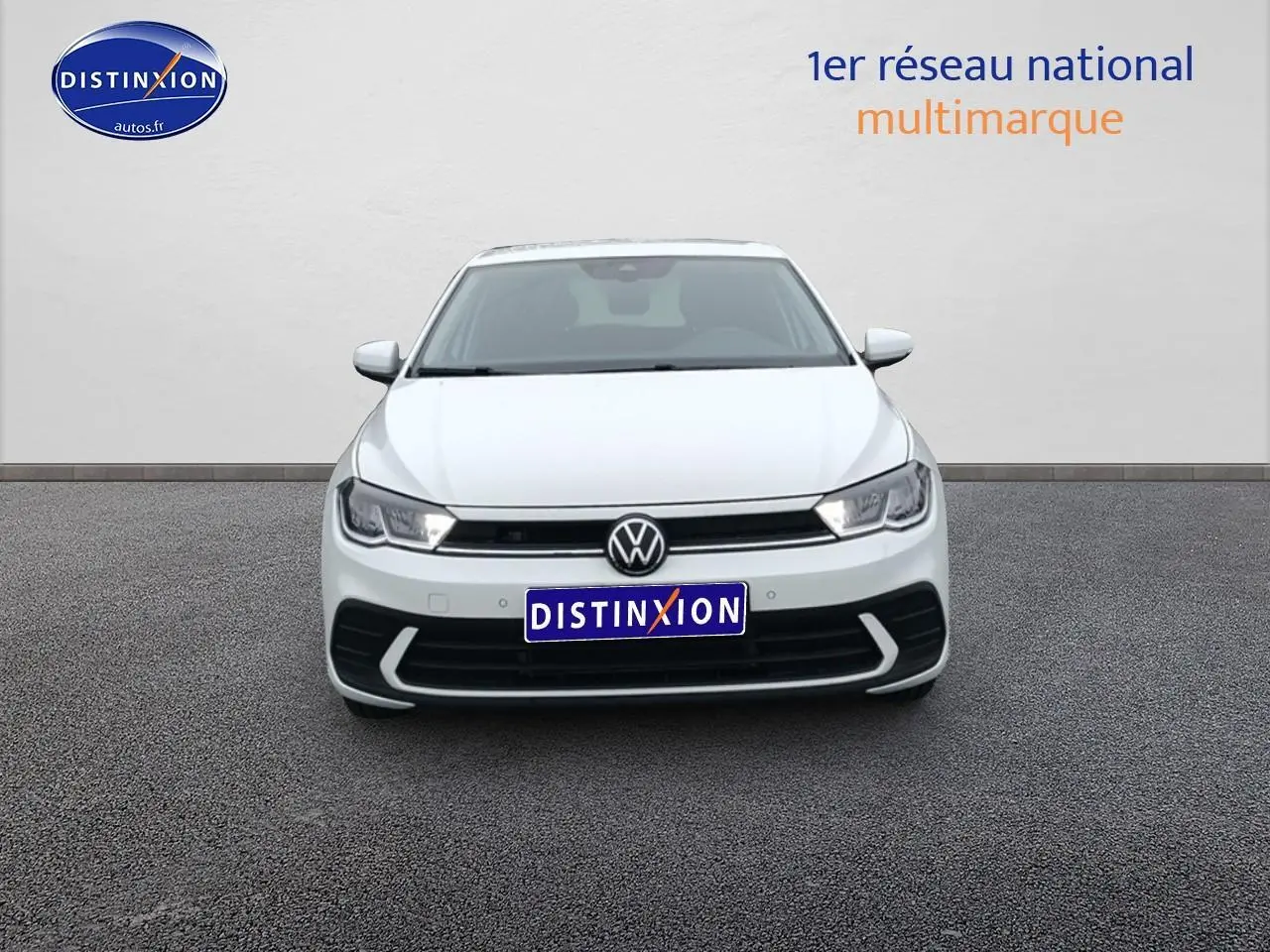 Vue de face d'une Volkswagen Polo blanche pure 2025 avec calandre noire et feux LED allumés.