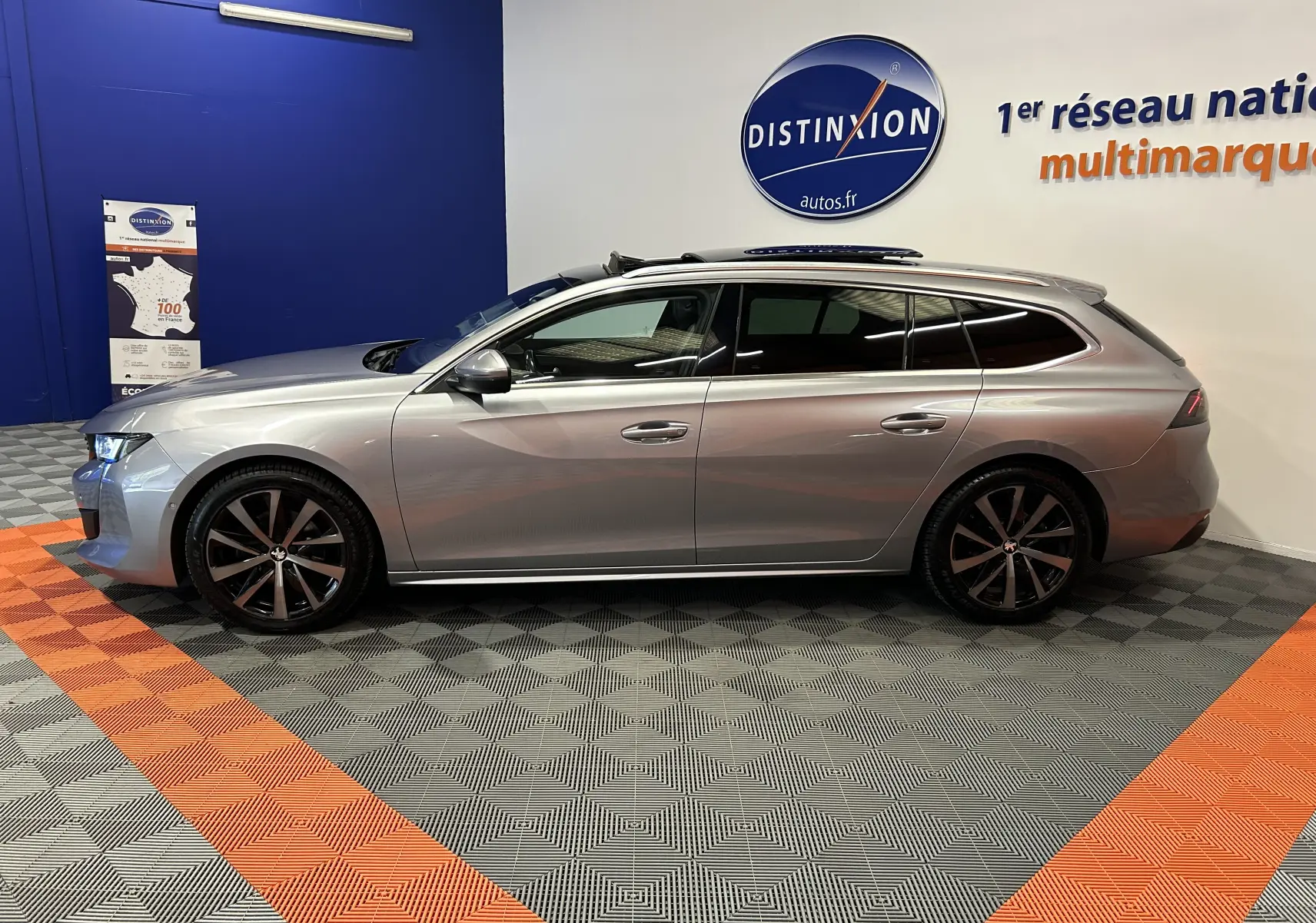 Peugeot 508 SW gris Platinium vue de profil côté gauche, avec toit ouvrant et jantes noires distinctives.