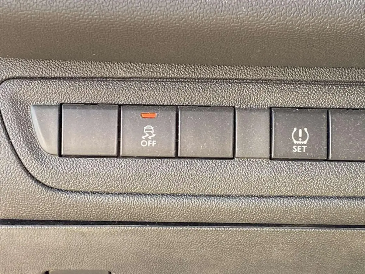 Gros plan sur les boutons de contrôle du tableau de bord d'une Peugeot 208 noire, version Like 2015.