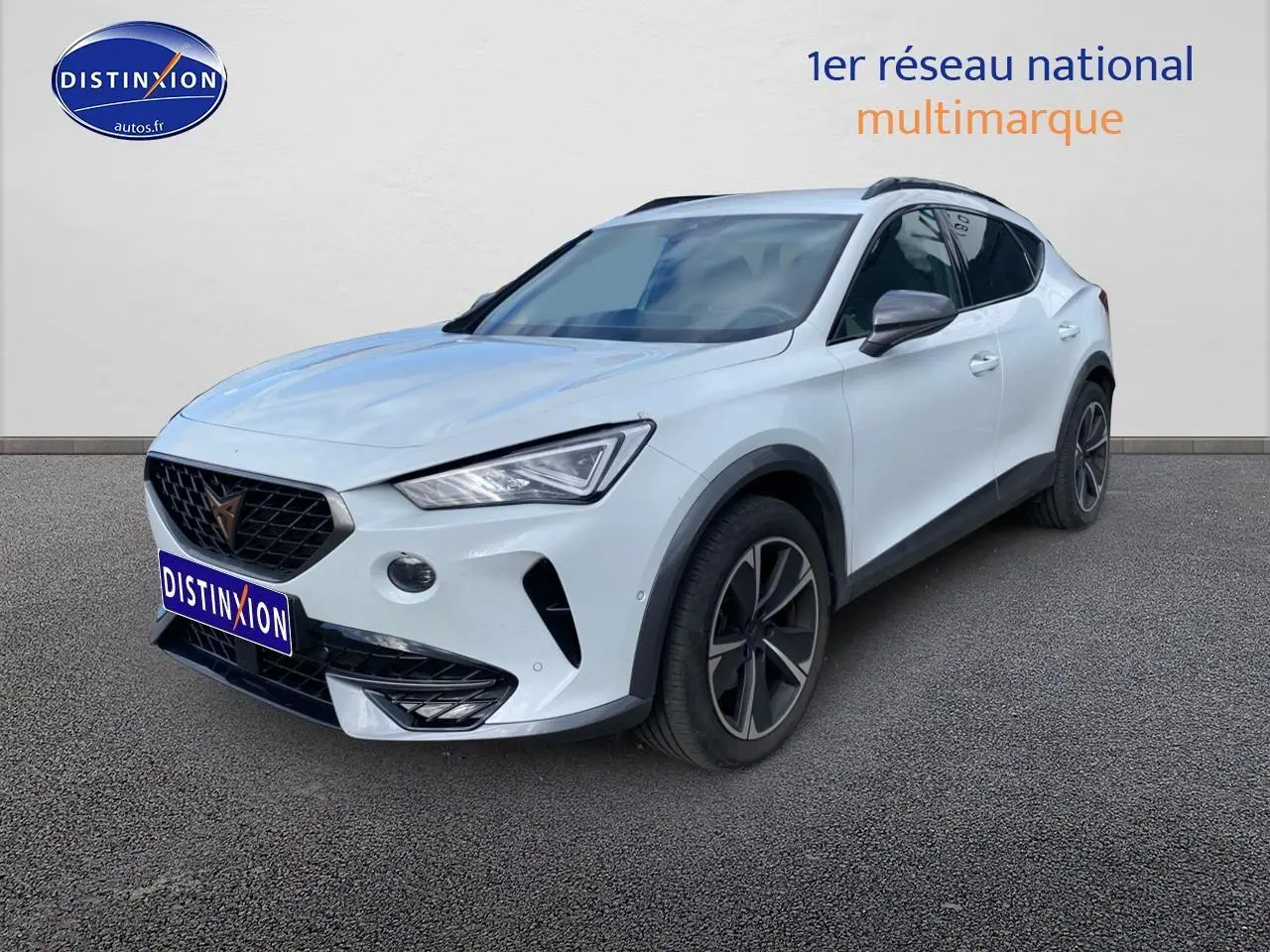 Vue 3/4 avant d'un CUPRA Formentor blanc avec jantes alu et calandre noire distinctive.