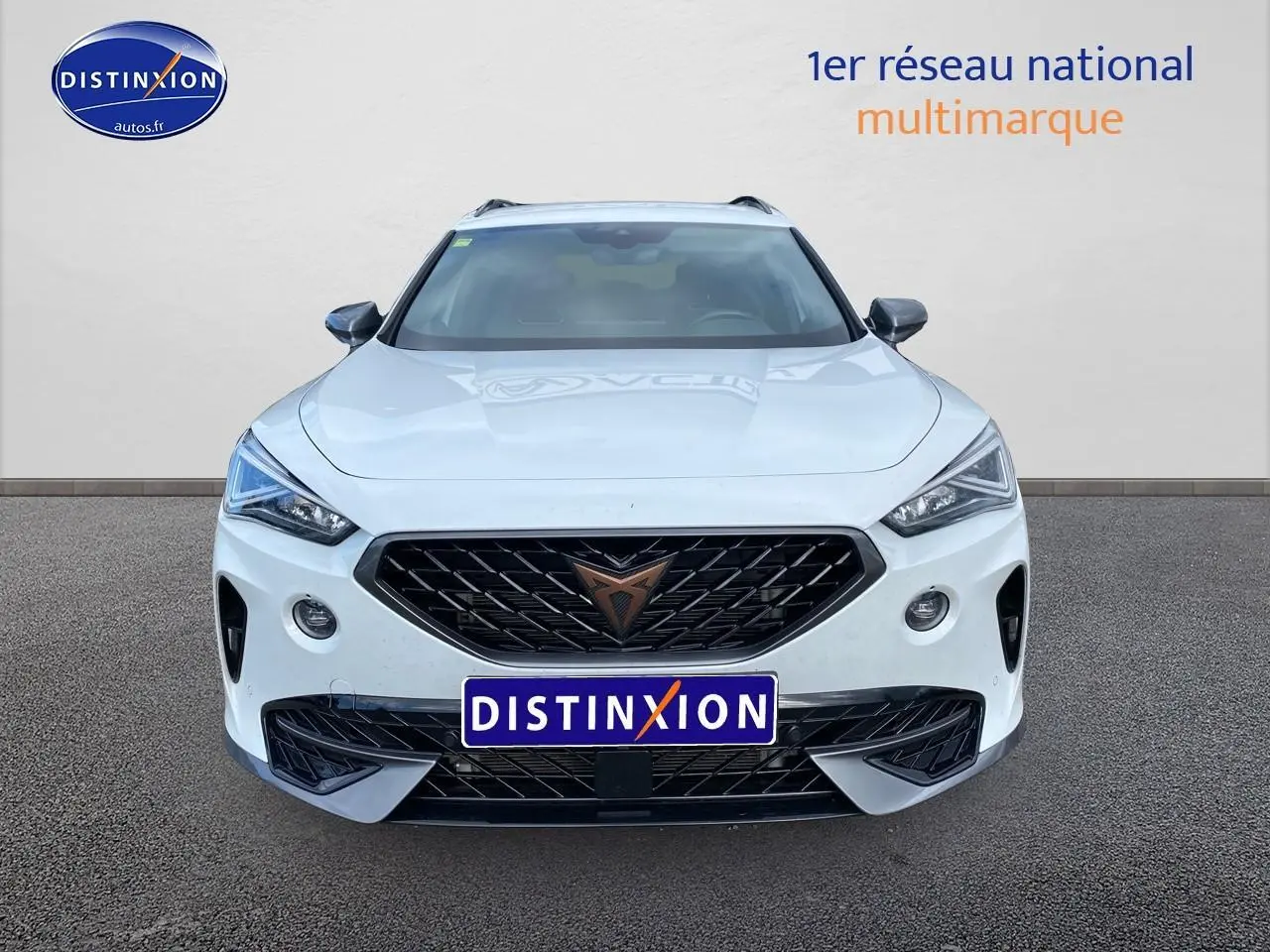 Vue frontale d'un CUPRA Formentor blanc 2023 avec calandre noire et logo cuivre, sur fond neutre.