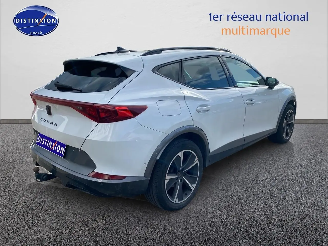 Vue 3/4 arrière droite du CUPRA Formentor blanc 2023 avec jantes alu noires et attelage visible.