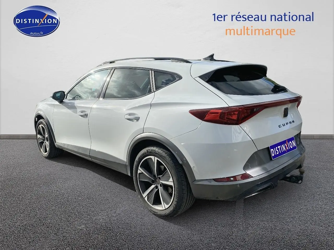 Vue 3/4 arrière droite d'un CUPRA Formentor blanc avec jantes alu et attelage visible sur fond neutre.