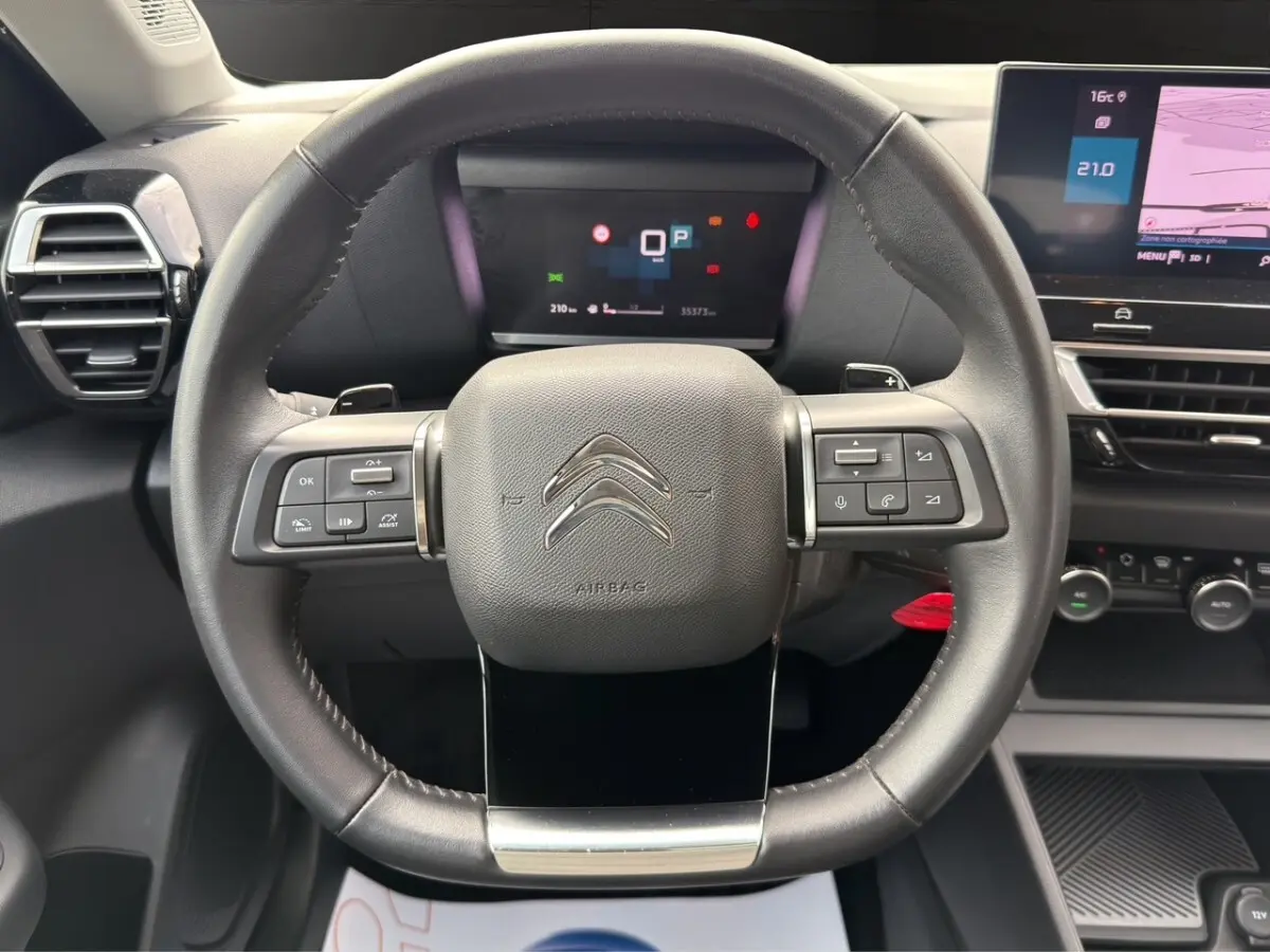 Vue frontale du volant cuir noir de la Citroën C4 2023 avec commandes multifonctions et tableau de bord digital.