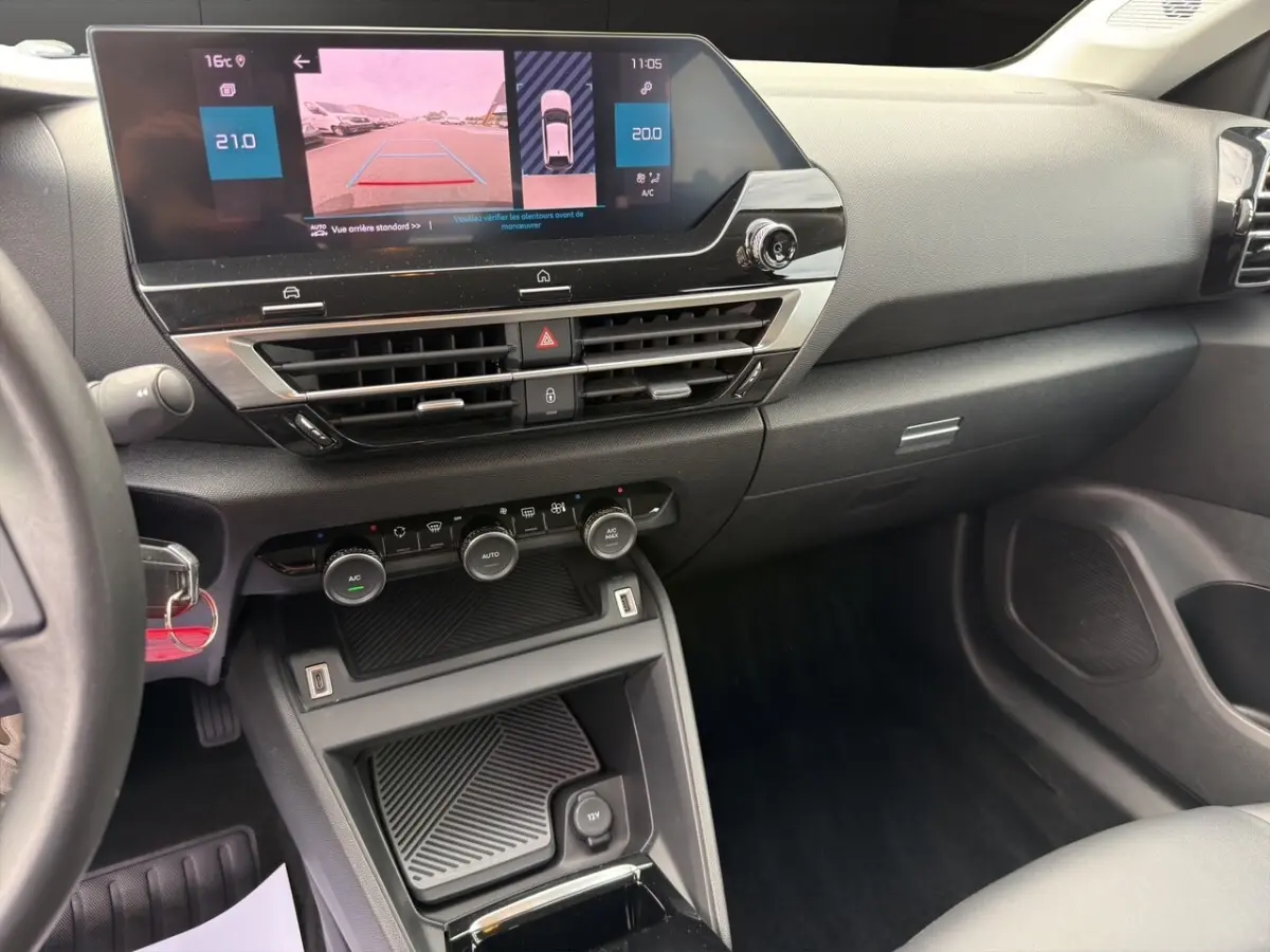 Vue intérieure de la planche de bord et console centrale du Citroën C4 2023 avec écran tactile et commandes climatisation.