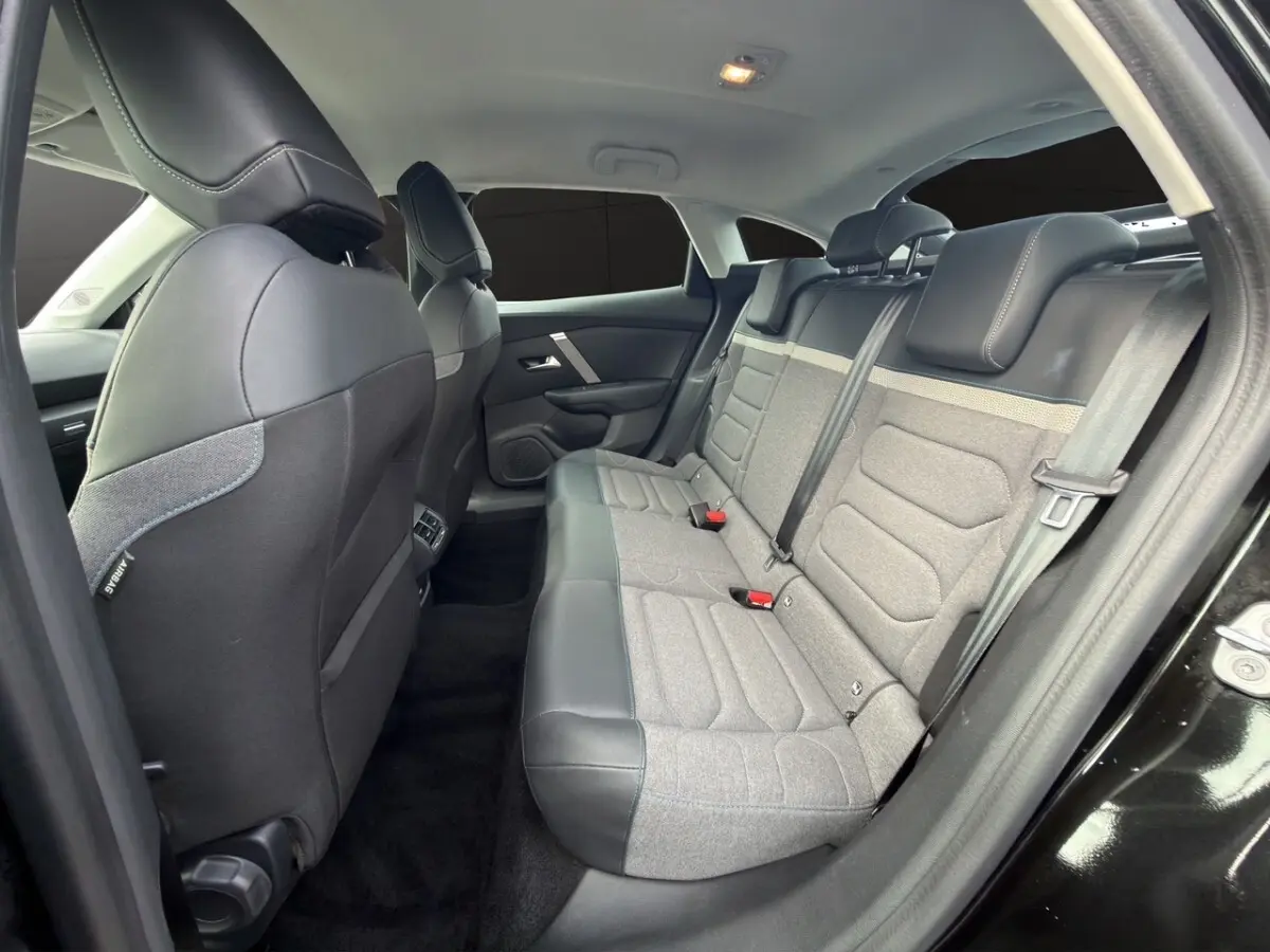 Intérieur arrière de la Citroën C4 2023 noir, vue côté droit montrant la banquette bi-matière gris et noir avec appuie-têtes.
