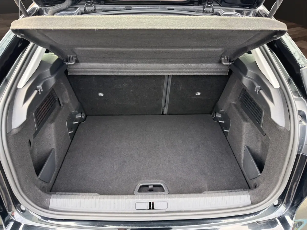 Coffre ouvert de la Citroën C4 noir 2023, vue arrière montrant l'espace de chargement vide et la tablette de coffre relevée.