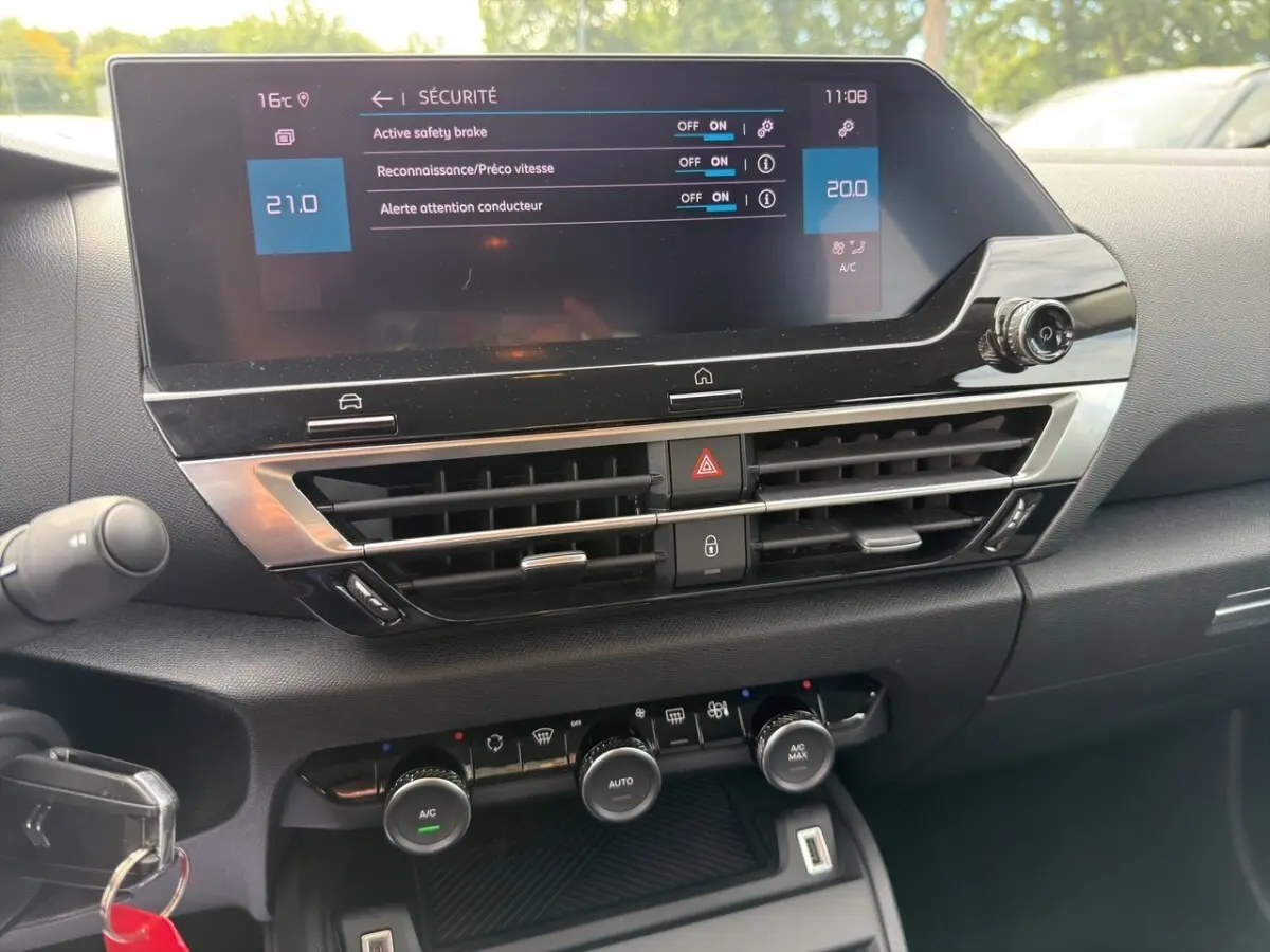 Tableau de bord central de Citroën C4 2023 avec écran tactile 10 pouces et commandes climatisation visibles.