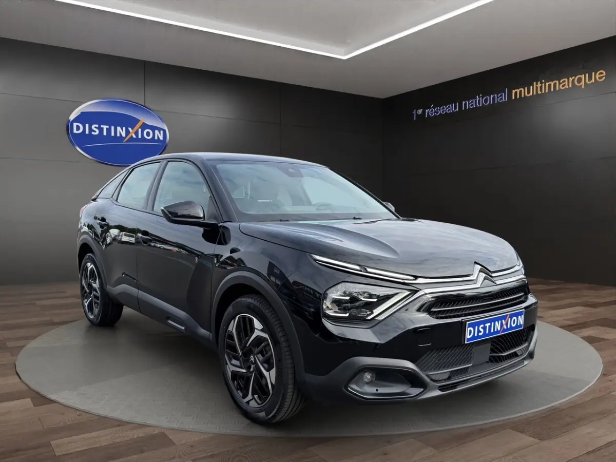 Citroën C4 noir vue 3/4 avant droit, avec feux LED distinctifs et jantes bicolores stylisées.