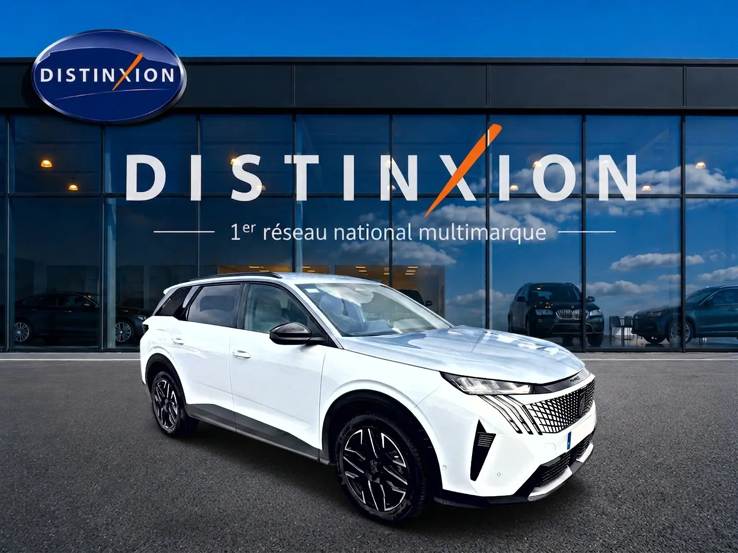Peugeot 5008 Hybrid 145 allure blanc en 3/4 avant droit, avec jantes alu noires et calandre distinctive.