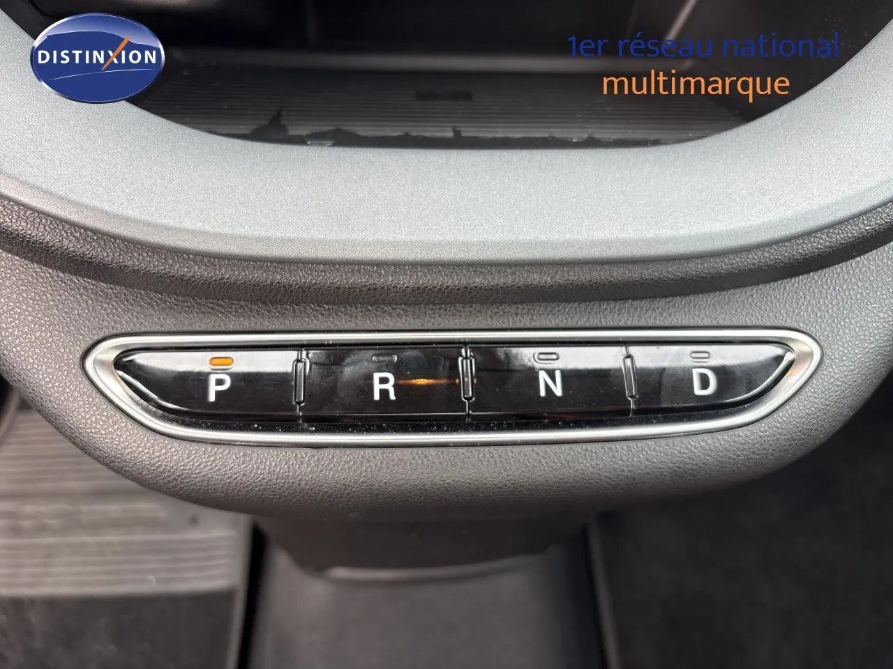 Gros plan sur la console centrale de la FIAT 500e rouge 2024 montrant les boutons de la boîte automatique P, R, N, D.