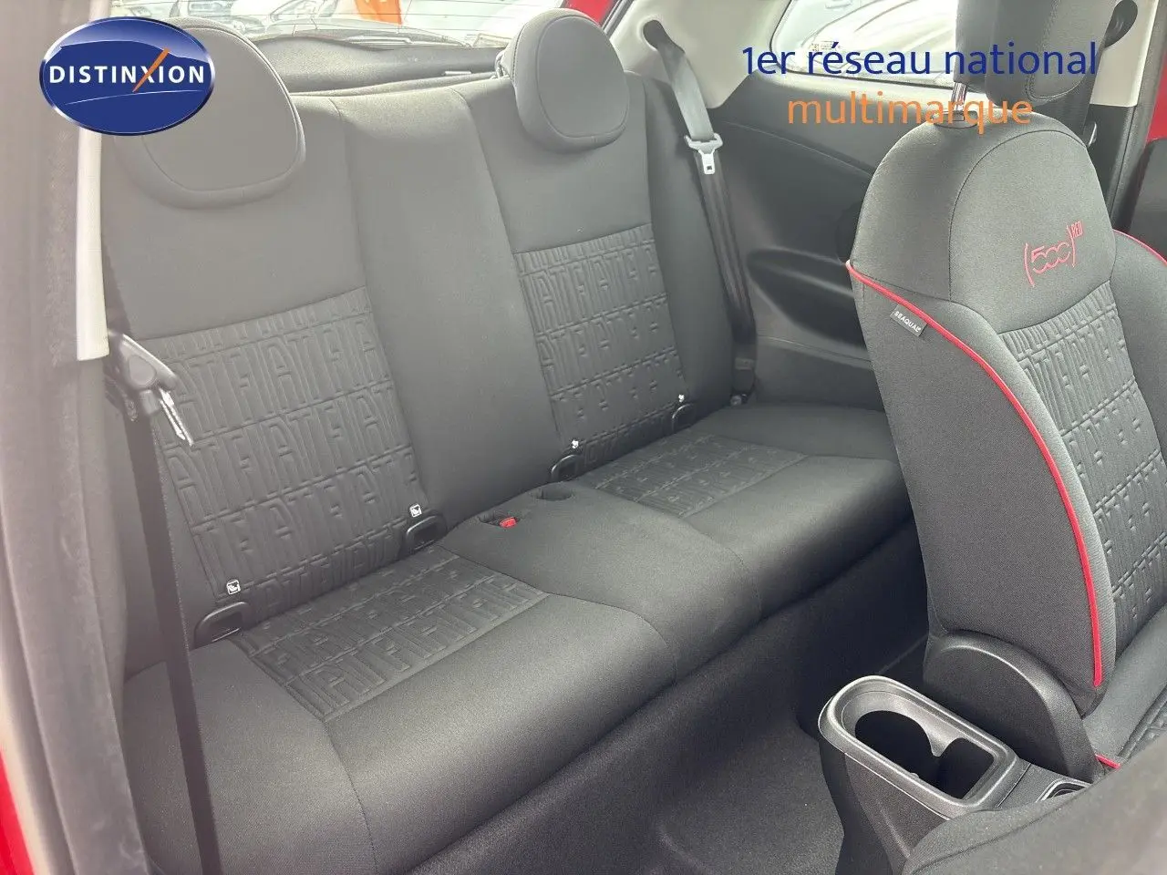 Vue intérieure montrant la banquette arrière et le siège avant droit noir avec surpiqûres rouges dans une FIAT 500e rouge.