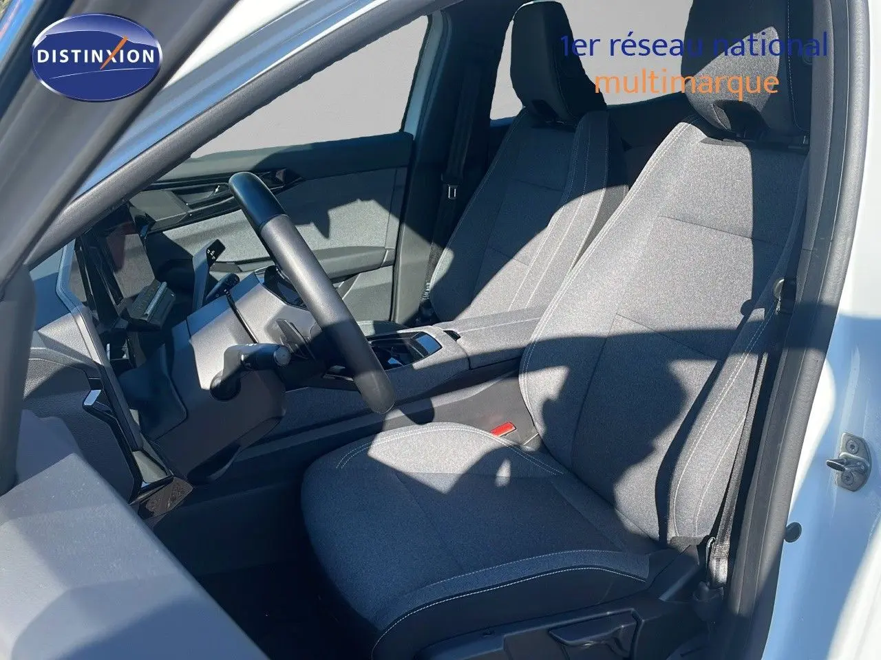 Intérieur côté conducteur du Renault Austral blanc glacier 2023, sièges tissu gris et tableau de bord moderne.