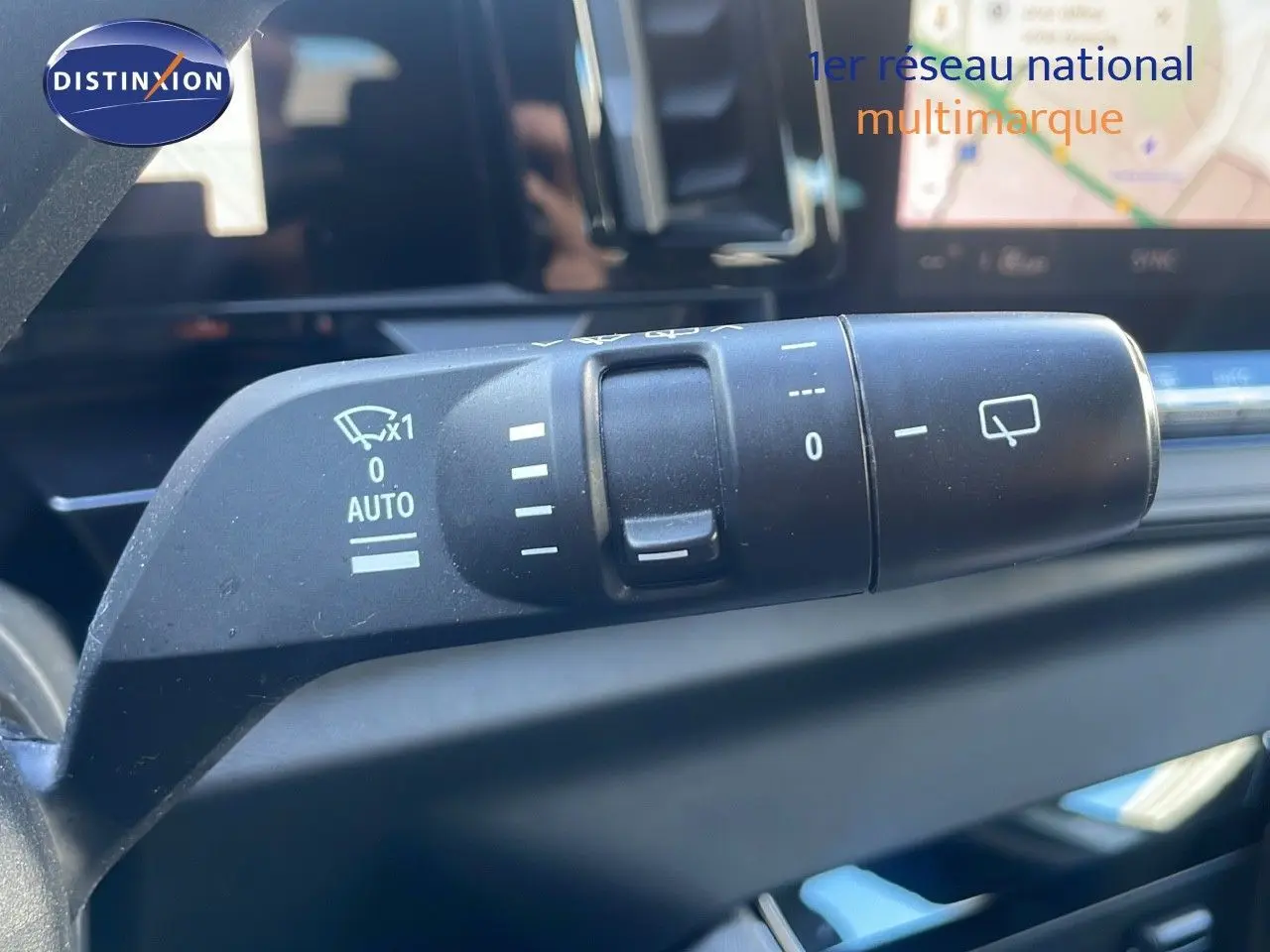 Gros plan sur la commande d'essuie-glace du Renault Austral 2023, intérieur avec écran tactile en arrière-plan.