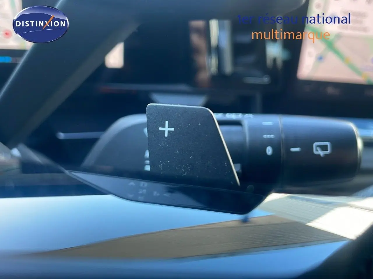 Gros plan sur la palette de changement de vitesse "+" du volant dans l'habitacle du Renault Austral blanc glacier.